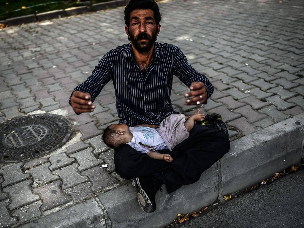 Donderdag 19 juni: Een Syrische vluchteling bedelt met zijn kind op schoot in de straten van Istanboel, Turkije. Door het geweld in Syrië zijn tienduizenden mensen gevlucht naar omliggende landen.