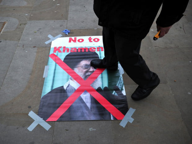 A protester steps on a poster of Iran's supreme leader Ayatollah Ali Khamenei during an opposition rally against the Iranian regime and the upcoming election in central London on May 15, 2013. AFP PHOTO/CARL COURTCARL COURT/AFP/Getty Images
